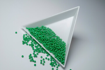 green beads in a white container © Vivianalens