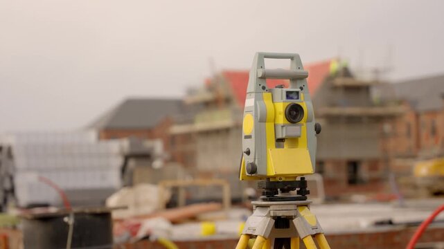 Surveying equipment is set up on a construction site to measure land and collect data for building projects