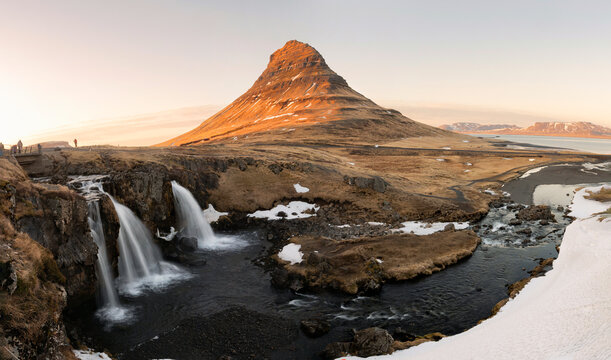 Panorama landscape of sunrise over volcanic Kirkjufell mountain with Kirkjufellsfoss waterfall in summer at Snaefellsnes peninsula, Iceland