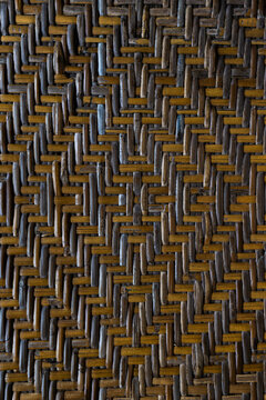 Intricate woven bamboo pattern with geometric diamond design and natural warm brown tones creating a textured background