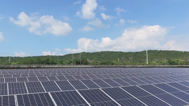 Drone moving forward over a solar farm under blue sky