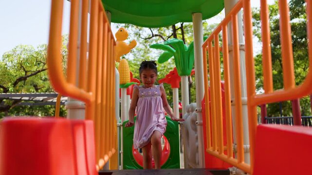 Young Thai Girl Playing on Colorful Outdoor Playground Equipment