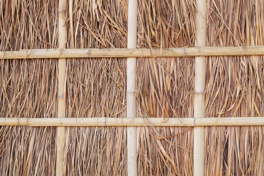 Natural bamboo frame dried palm leaf thatch forming rustic woven wall texture ideal for traditional architecture tropical design natural backgrounds