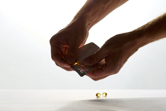 Hands Taking Out Vitamin Capsule from Blister Pack