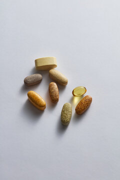 Variety of Daily Dietary Supplement Pills and Vitamin Capsules on White Background