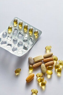 Assorted Vitamin Pills, Dietary Supplement Capsules, and Blister Pack on White Background