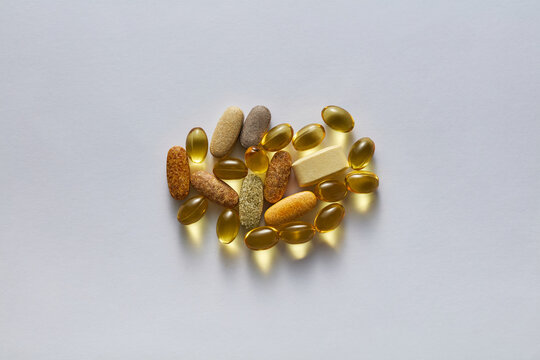 Assorted Dietary Supplements and Vitamin Softgel Capsules on White Background