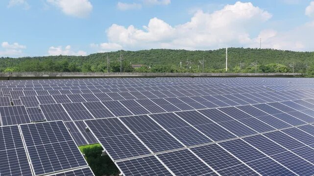 Drone gliding over solar panels in a green landscape
