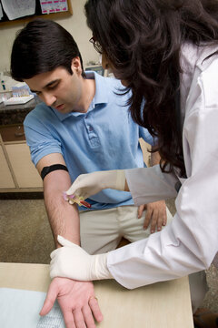 Doctor taking a blood sample from a man 