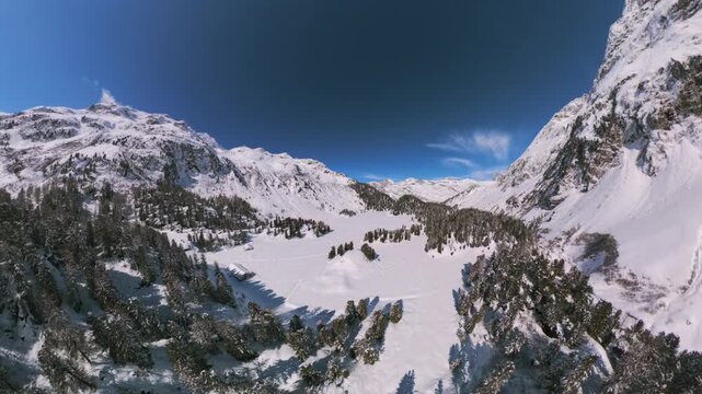 Snow covered frozen Lake Cavloc surrounded by pine forest in Maloja Pass, Switzerland. Aerial drone view