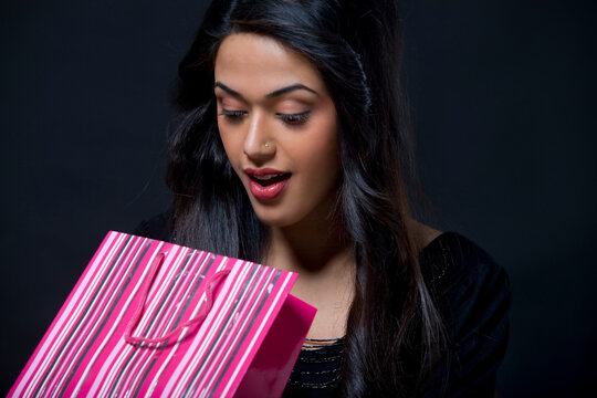 Young woman looking inside a shopping bag 