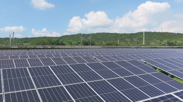 Aerial view over solar panels and wooded hills