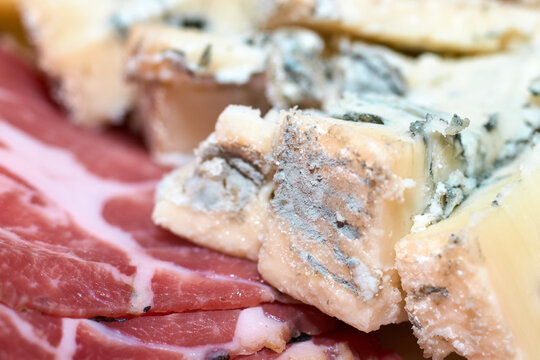 Close-up shot of blue cheese slices arranged nicely with cured meat cold cuts