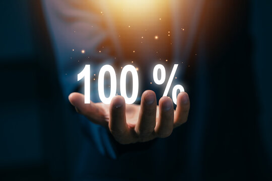 Business professional holding glowing 100 percent symbol, representing full achievement, customer satisfaction, quality assurance, performance, success, completion, and excellence concept.