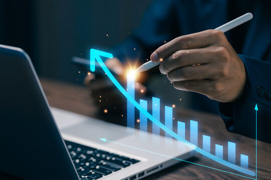 Business professional using stylus with rising digital chart on laptop, representing business growth, financial analytics, performance, investment, strategy, and data driven success.
