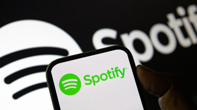 Spotify logo on smartphone screen with dark background representing global music streaming services.