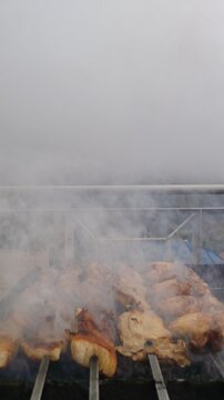 Barbecue on the fire. Delicious shashlik meat grilling on skewers over hot coals. Grilled shish kebab. Barbecue in the smoke