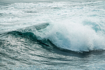 Fototapeta premium Close-up of a breaking ocean wave with turquoise water, white foam crest and dynamic motion