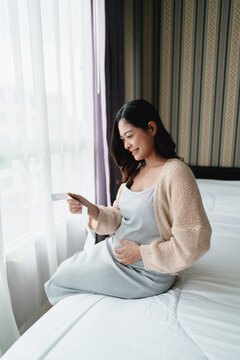 Pregnant woman looking at ultra sound paper of her Baby