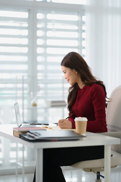 Portrait of confident Asian businesswoman working in office