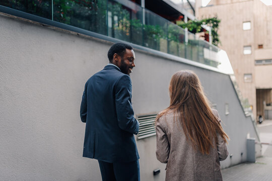 Business people walking and talking in city street