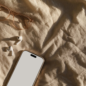 Minimalist Morning Setup with Glasses, Smartphone, and Earbuds