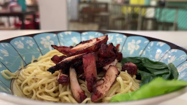 Close up view of noodle on the bowl. chicken charsiu and mustard greens leaves. side, front. mie, bakmi.