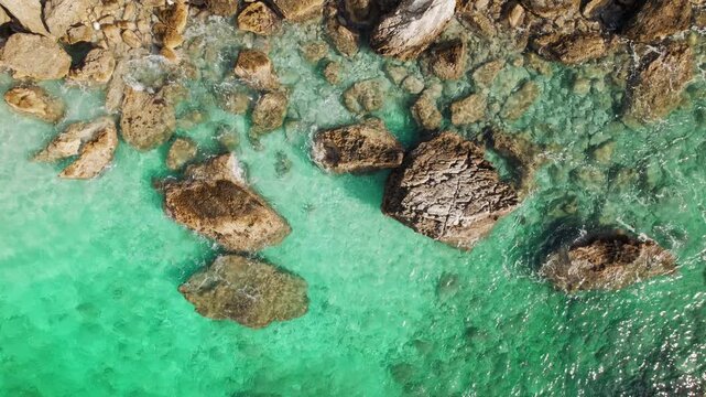 Top down view of rocks in clear turquoise shallow sea water