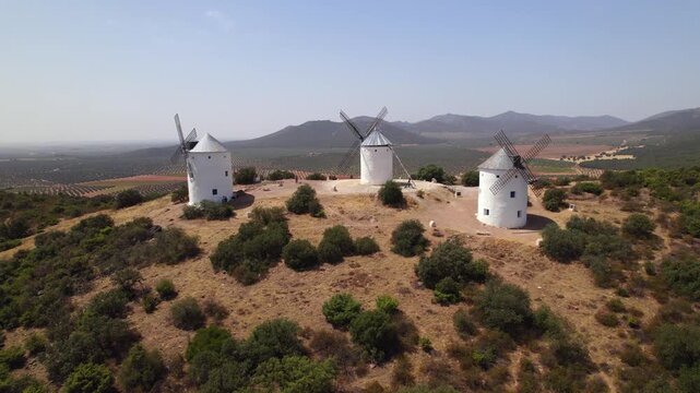 Historic white windmills of Puerto Lapice on a sunny hill in La Mancha, Spain famous for Don Quixote