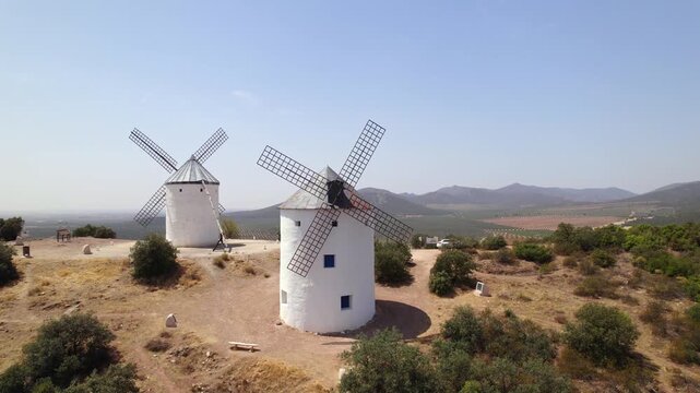 Historic Puerto Lapice windmills spinning on a hill in La Mancha, Spain on a sunny summer day, the land of Don Quixote