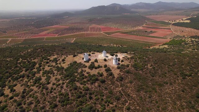 Aerial view of historic Puerto Lapice windmills descending towards the famous landmarks on a sunny day in La Mancha, Spain