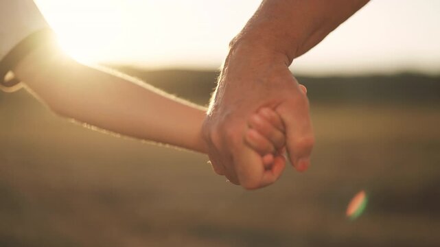Family ties, closeup view of grandfather and grandson hands, holding in nature. Old man and little boy stretching hands to each other, love and care, continuity of generation, people connection