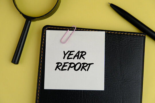 Business concept for YEAR REPORT written on sticky note paper on black notebook background. Conceptual hand writing text caption inspiration showing Annual Report.