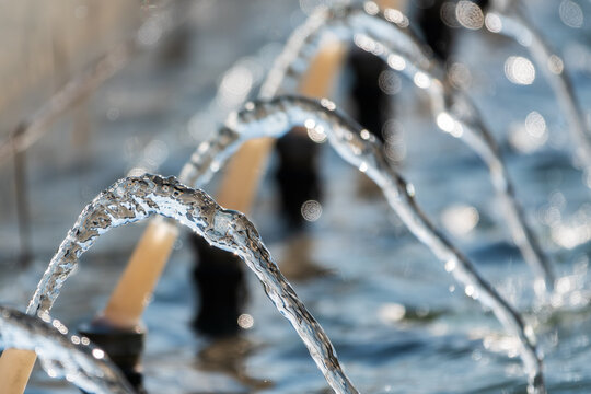 Splashes and jets of water against light background.