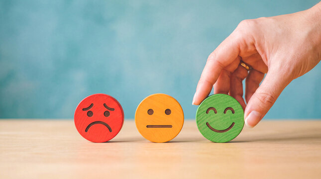Hand selecting a happy face emoji from a row of emotion icons