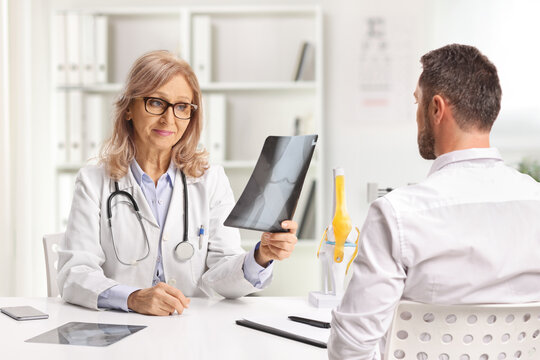 Female doctor showing x-ray scan to a male patient
