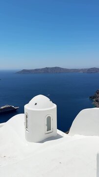 White architecture in Santorini island, Greece. Blue sea and the blue sky at sunny day. Panoramic view of the island. Travel and summer vacation concept. Vertical video
