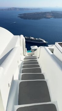 White architecture in Santorini island, Greece. Steps to the sea. Blue sea and the blue sky at sunset. Travel and summer vacation concept. Vertical video
