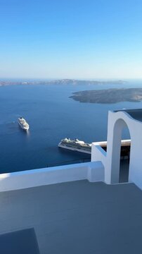 Beautiful sunset at Santorini island, Greece. Terrace with sea view. Panoramic view of the island. Cruise ships near the island. Summer travel and vacation. Vertical video
