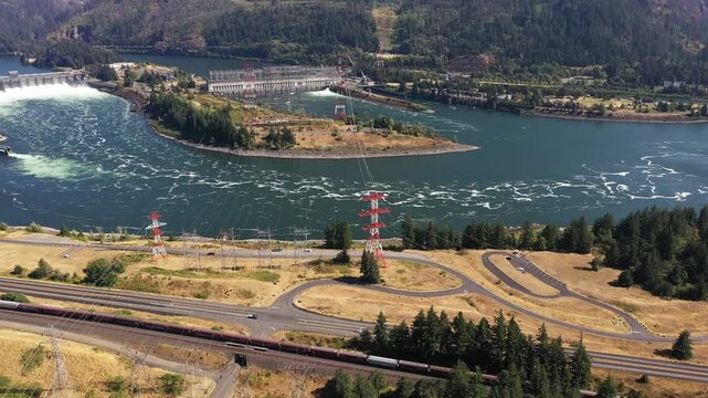 4K aerial drone footage of Bonneville Dam in Columbia River Gorge, Oregon, USA, releasing powerful water through spillways between Oregon & Washington, showcasing hydroelectric power, renewable energy