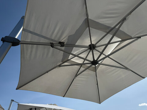 Umbrella on the beach against a blue sky, close-up
