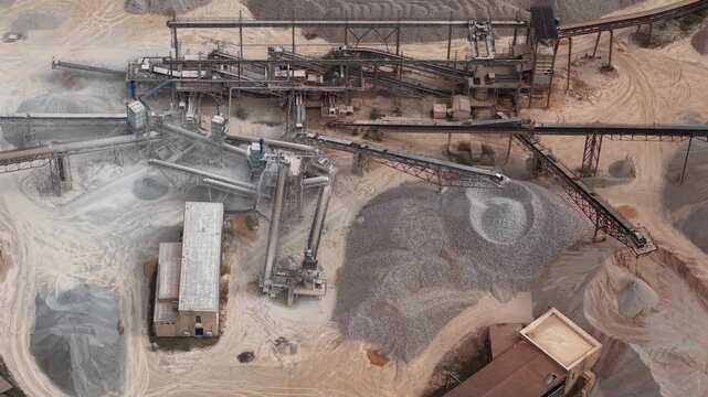Aerial view of an industrial quarry processing aggregate and stone using conveyor belts and machinery.