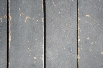 Fototapeta premium Weathered gray wooden planks with visible grain, seams, scratches, peeling paint, and natural imperfections, creating a rustic textured background for design and copy space.