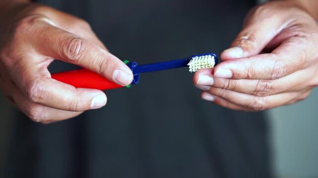 A hand is holding a foldable toothbrush, an essential item for travel.