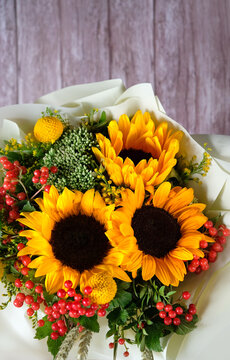 Beautiful autumnal bouquet with sunflowers close up on wooden background. seasonal floristic composition. symbol of indian summer, august, end summer, autumn, 1 september. top view. copy space