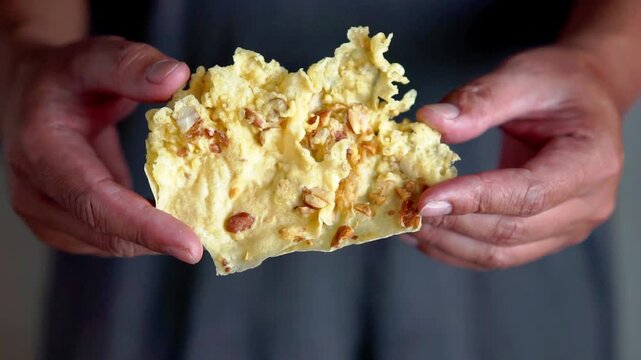 Rempeyek (peyek) is a side dish made from a batter of rice flour, water, coconut milk, and ground spices, topped with peanuts.