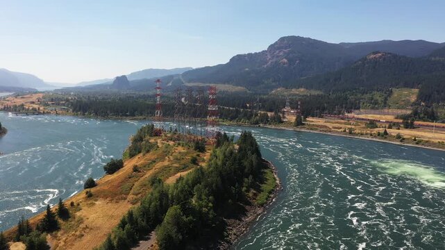 4K aerial drone footage of high voltage transmission towers on Bradford Island carrying hydroelectric power from Bonneville Dam across Columbia River toward Washington, Oregon, USA, electrical grid