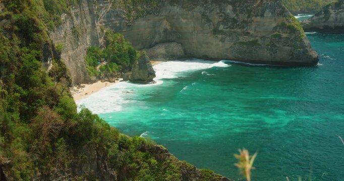 Tropical bay with ocean waves and lush greenery at Diamond Beach on Nusa Penida Indonesia
