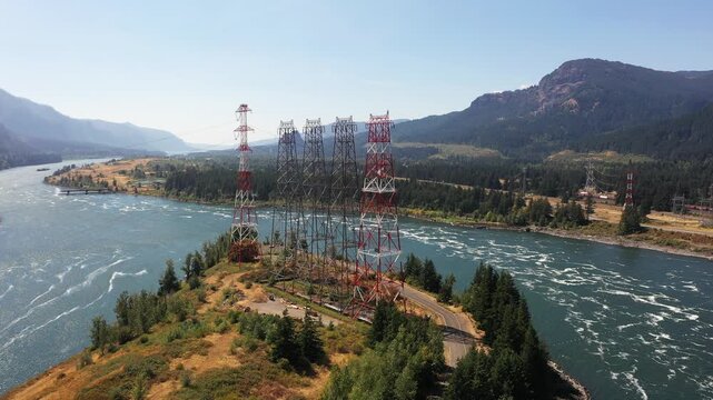 4K aerial drone footage of high voltage transmission towers on Bradford Island carrying hydroelectric power from Bonneville Dam across Columbia River toward Washington, Oregon, USA, electrical grid