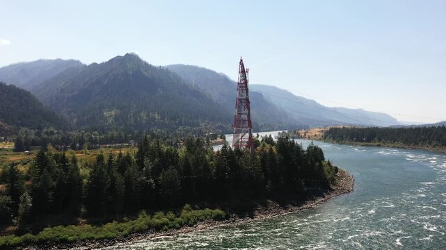 4K aerial drone footage of high voltage transmission towers on Bradford Island carrying hydroelectric power from Bonneville Dam across Columbia River toward Washington, Oregon, USA, electrical grid